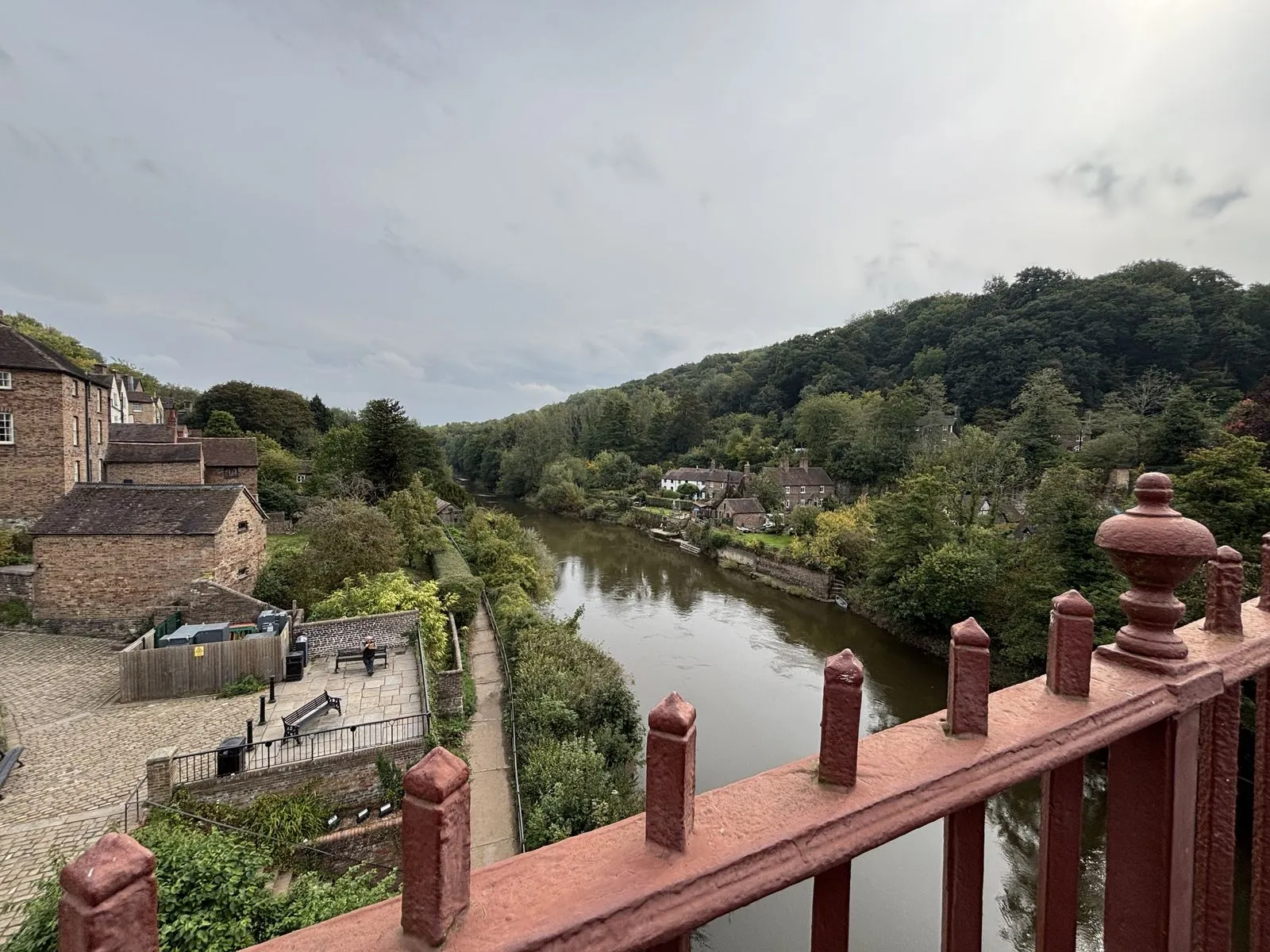 Looking down the River Severn from the Iron Bridge, over its red cast-iron railing